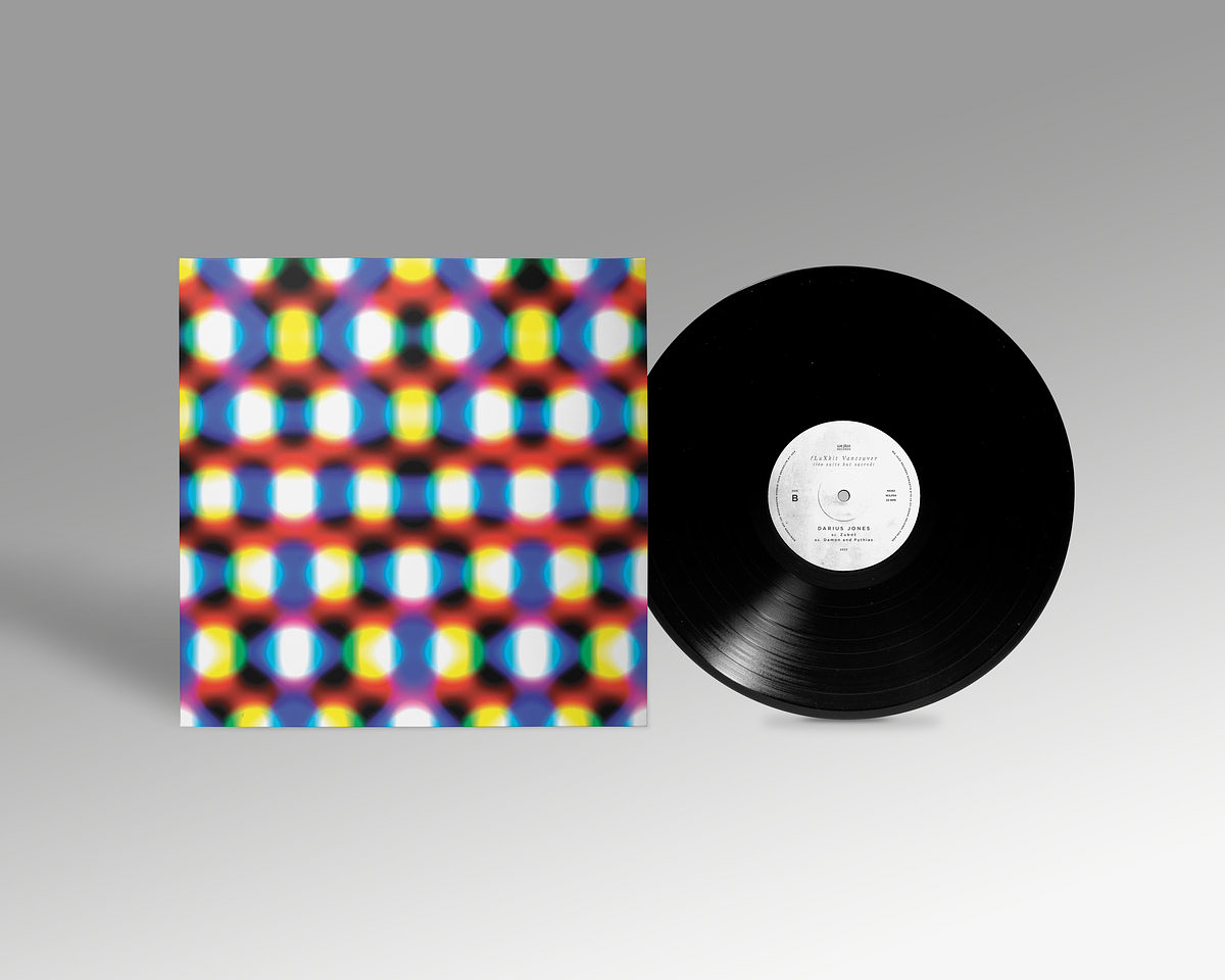A vinyl record slides out of its jacket. The cover art shows a geometric pattern of overlapping blue, yellow, and red circles. 