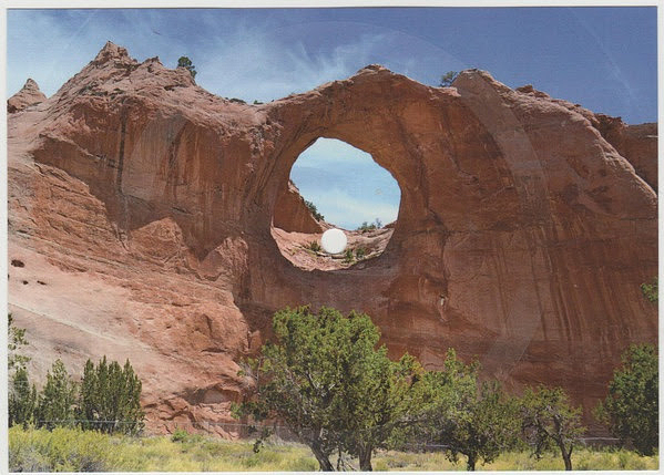 A colour photo of Tségháhoodzání, a large sandstone formation with a hole through it, located in Arizona, US. The image has been modified by a white circle placed in the middle of the hole and concentric circles radiating out from this.