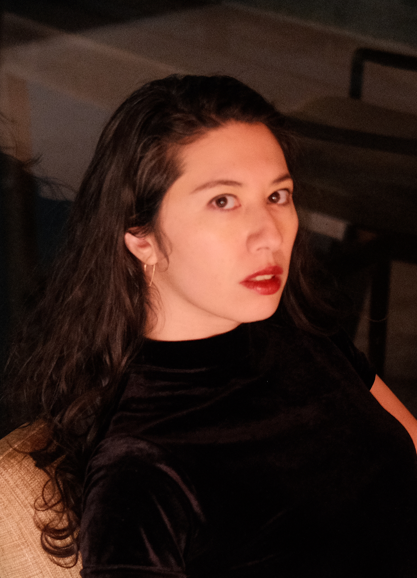 A headshot portrait of Leanne Dunic. She wears a black shirt while sitting looking to her right, towards the camera.