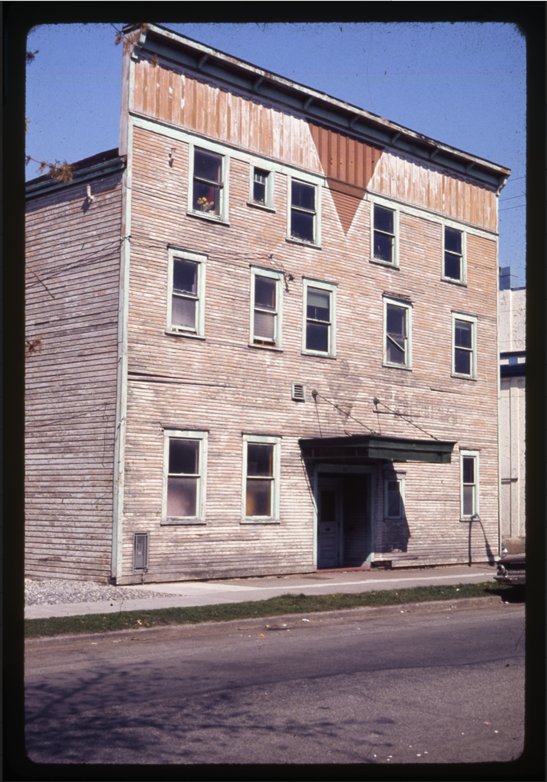 A colour photograph that looks north onto Western Front’s facade. The wooden siding is old and the paint faded.